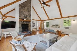 a living room with a white couch and a fireplace at Wildflower Retreat in Kennebunk