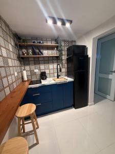 a kitchen with blue cabinets and a black refrigerator at Gibertino by Cinque Terre in Isabela
