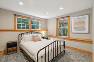 a bedroom with a bed and two windows at Wildflower Retreat in Kennebunk +43 photos
