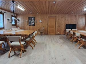 a large room with wooden walls and tables and chairs at Furudals Bruk in Furudals Bruk
