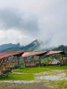 a group of wooden buildings with mountains in the background at Conexión naturaleza in San Luis