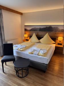 a bedroom with a large bed and a chair at König Ludwig Stub´n in Prien am Chiemsee