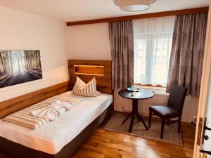a bedroom with a bed and a table and a window at König Ludwig Stub´n in Prien am Chiemsee +22 photos