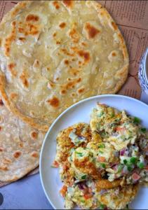 a plate of omelet and a plate of food at The Eastern Lodge in Islamabad