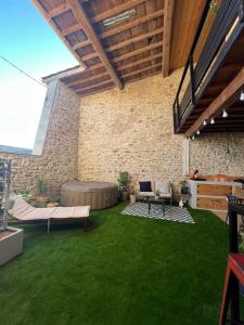 a patio with green grass and a brick wall at Villa Valent in Cazilhac
