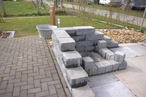 a block retaining wall in a yard with a bucket at Weserberglandalm Haus 3 in Ottenstein +14 photos