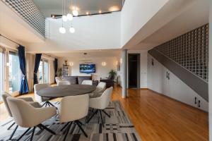 a dining room and living room with a table and chairs at Villa Poljine GREEN in Sarajevo
