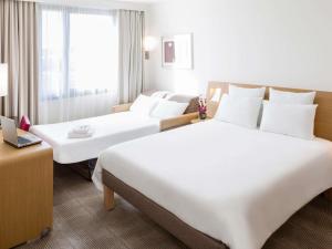 a hotel room with two beds and a laptop at Novotel Antwerpen - Ekeren in Antwerp +129 photos