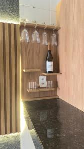 a bottle of wine on a shelf in a room at Loft Completo Compact in Palmas