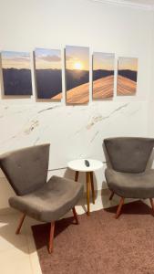 two chairs and a table in a room at Loft Completo Compact in Palmas +9 photos