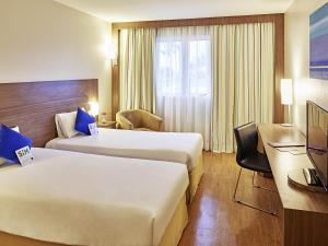 a hotel room with two beds and a desk at Novotel Manaus in Manaus