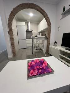 a kitchen with a table with a bowl of flowers on it at Estudio Bajamar in Torre del Mar