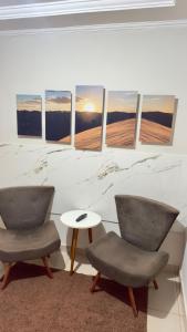 two chairs and a table in a room at Loft Completo Compact in Palmas
