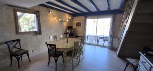 a dining room with a table and chairs and a window at Mes maisons à la Pinède in Sainte-Maxime