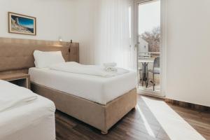 a bedroom with two beds and a balcony at Lavanda Rooms & Apartment - Malinska in Malinska