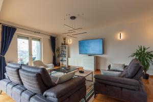 a living room with two couches and a flat screen tv at Villa Poljine GREEN in Sarajevo