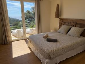 a bedroom with a bed and a large window at La roche aux mouettes Ile du Levant in Île du Levant