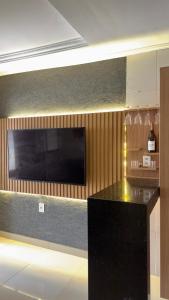 a kitchen with a black counter top and a television at Loft Completo Compact in Palmas