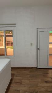 a white room with two doors and a wooden floor at Monterrico VIP in La Candelaria +4 photos