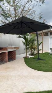 a black umbrella sitting on top of a lawn at Monterrico VIP in La Candelaria