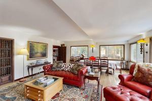 a living room with red couches and a table at Hidden Haven in Bath