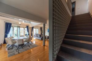 a dining room and living room with a table and chairs at Villa Poljine GREEN in Sarajevo