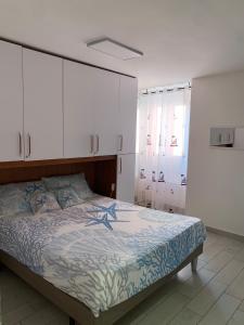 ein Schlafzimmer mit einem Bett und weißen Schränken in der Unterkunft Casa Mareo in Capraia