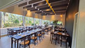 a restaurant with tables and chairs and a large window at Howard Johnson Plaza & Convention Center Spa La Plata in La Plata