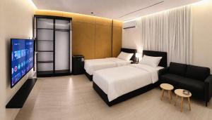 a bedroom with a bed and a couch and a tv at رولارا بلازا in Medina