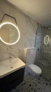 a bathroom with a sink and a toilet and a mirror at Hil's Bay View - Terra in Lepetani
