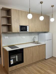 a kitchen with wooden cabinets and a sink and a microwave at Hil's Bay View - Terra in Lepetani +19 photos