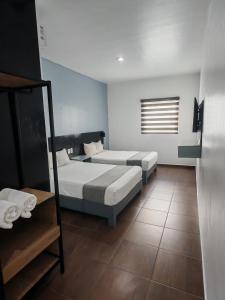a bedroom with two beds and a window at Aló Select Mazatlan in Mazatlán