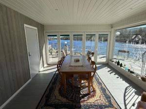 a dining room with a table and views of the water at Villa Heyerdahl Main House in Åmli