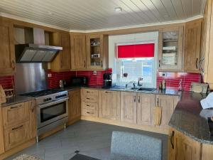 a kitchen with wooden cabinets and a stove top oven at Villa Heyerdahl Main House in Åmli +29 photos