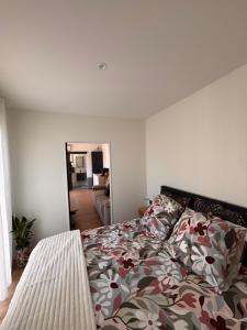 a bedroom with a bed with a floral comforter at La parenthèse boisée in La Chapelle-en-Serval