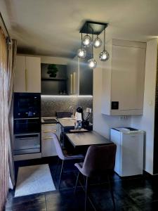 a kitchen with a table and chairs in it at MonDa apartman in Salgótarján