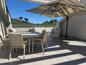 a table and chairs on a balcony with an umbrella at Terrazza Belvedere in Melfi