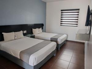 a bedroom with two beds and a window at Aló Select Mazatlan in Mazatlán +5 photos