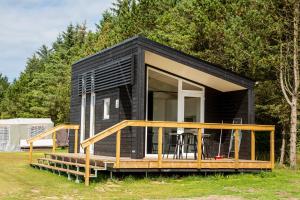 a black tiny house with a large deck at DCU-Camping Tranum in Brovst