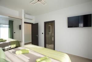 a bedroom with two beds and a flat screen tv at Villa Vox in Labin