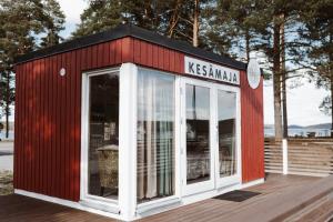a red and white building on a wooden deck at Palas Kesämaja in Padasjoki