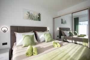 a bedroom with a large bed with green pillows at Villa Vox in Labin