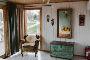a room with a chair and a mirror and a table at Palas Kesämaja in Padasjoki