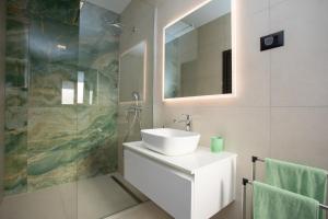 a white bathroom with a sink and a mirror at Villa Vox in Labin +25 photos