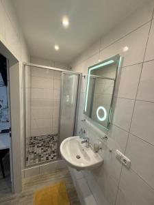 a bathroom with a sink and a shower with a mirror at Gaststätte und Hotel zur Krone in Pohlheim