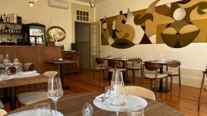 a restaurant with tables and chairs with wine glasses at Vila Camélia in Porto