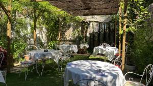 two tables and chairs with white table cloths in a garden at Vila Camélia in Porto