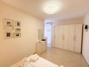 a white room with a bed and a dresser at Bogdani Apartment in Golem
