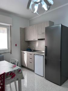 a kitchen with a stainless steel refrigerator and a table at Casa Vacanze Falco in Agropoli