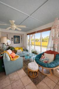 a living room with two couches and a window at Creekside Paradise in Tybee Island